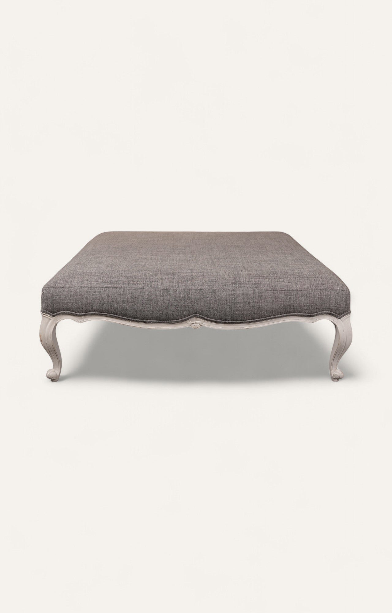 Elegant Gray Ottoman with Sculpted Wooden Legs