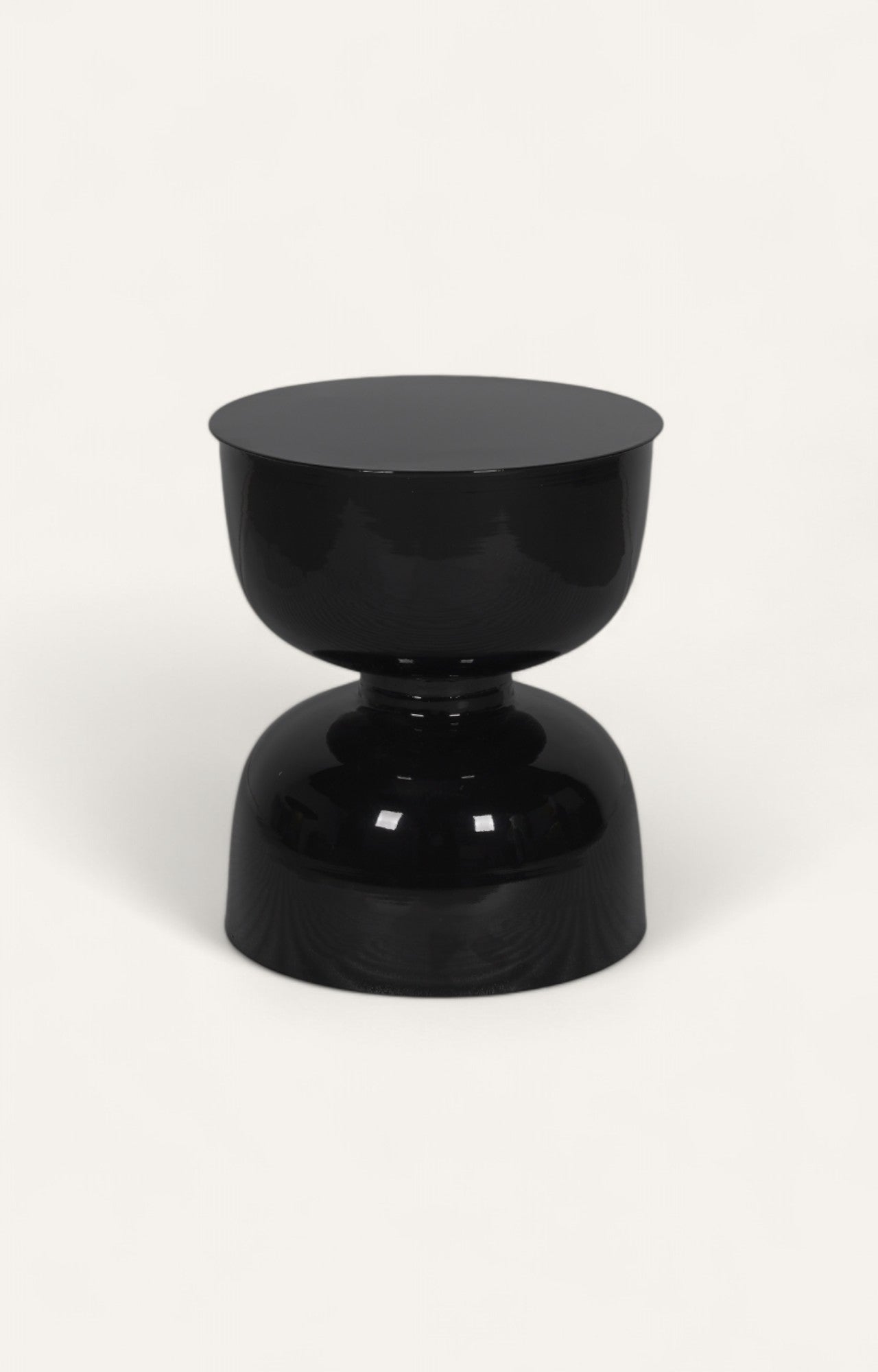 Glossy black metal side table in hourglass design.