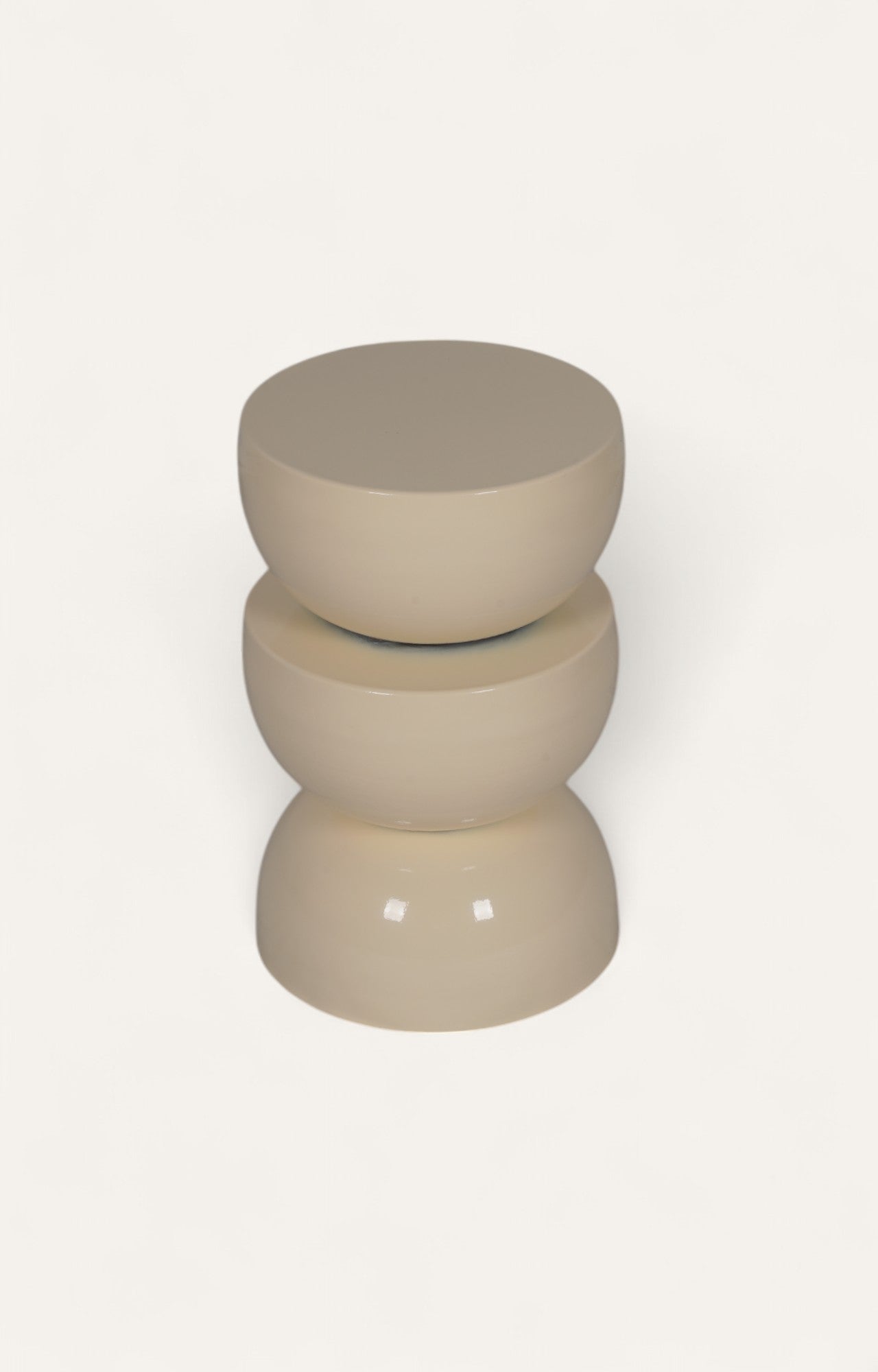 White cream-colored sculptural metal side table with three curved tiered design.