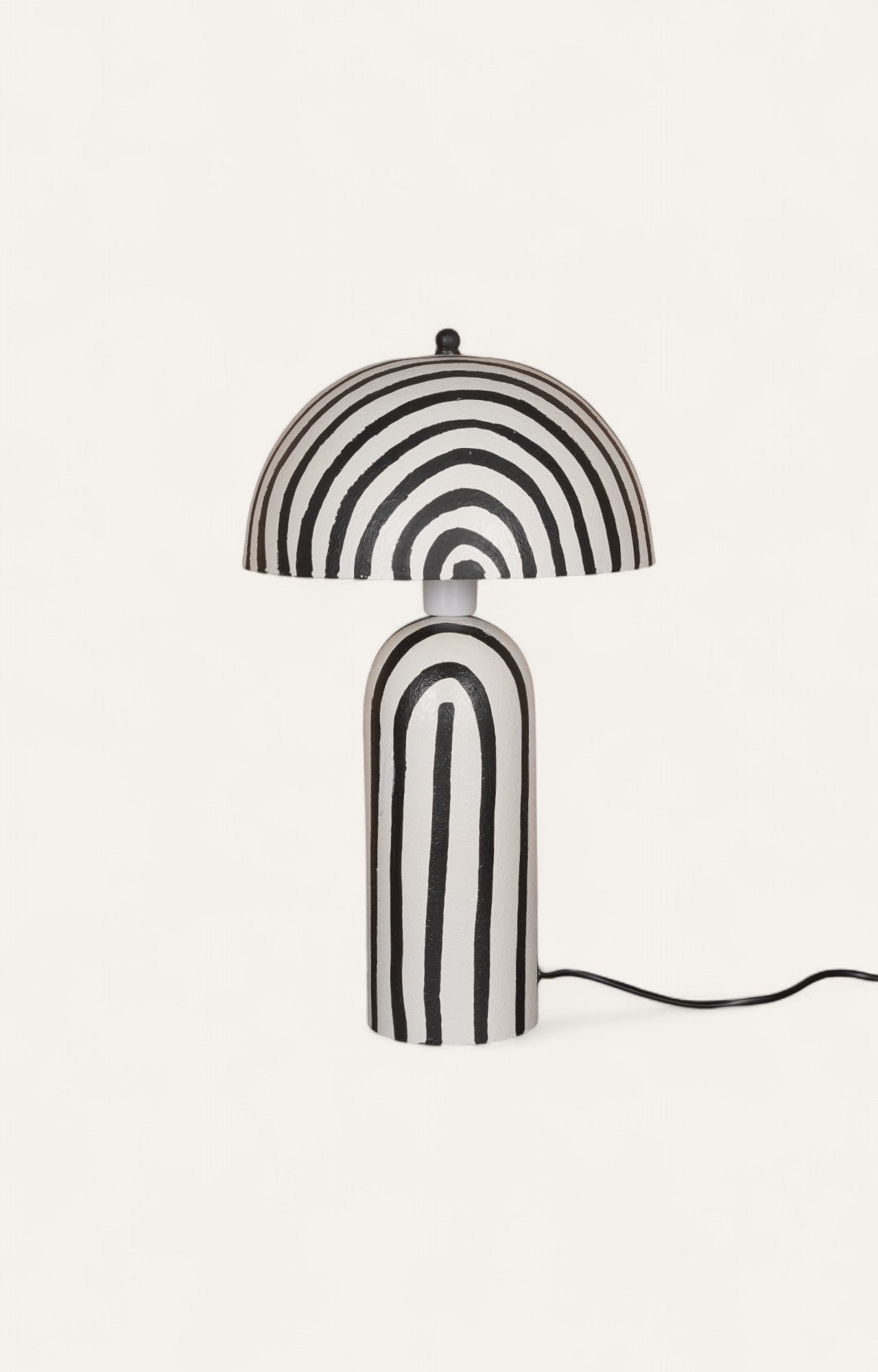 Table lamp made of Plaster of Paris with bold black and white stripes in a cylindrical and mushroom shape.