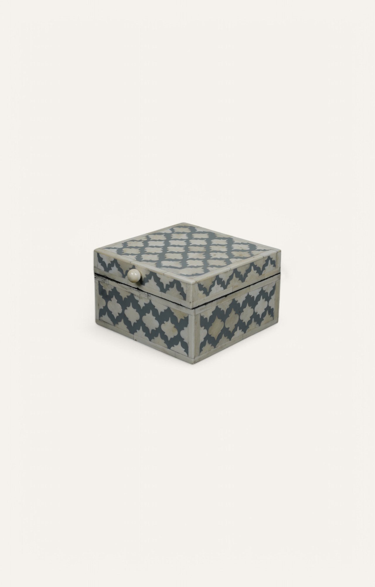 Compact cube box with white bone inlay on blue resin, featuring jail-style repeat motif.
