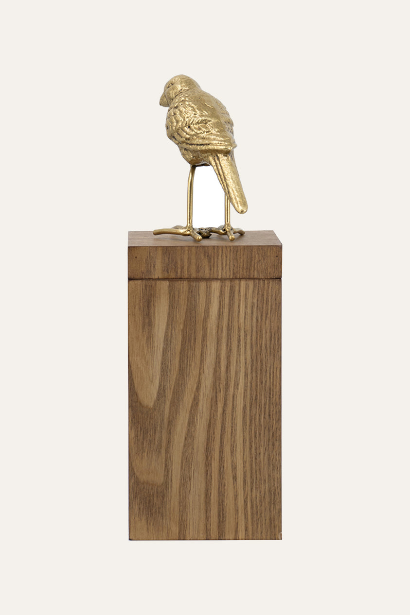 parrot sculpture on wooden pedestal