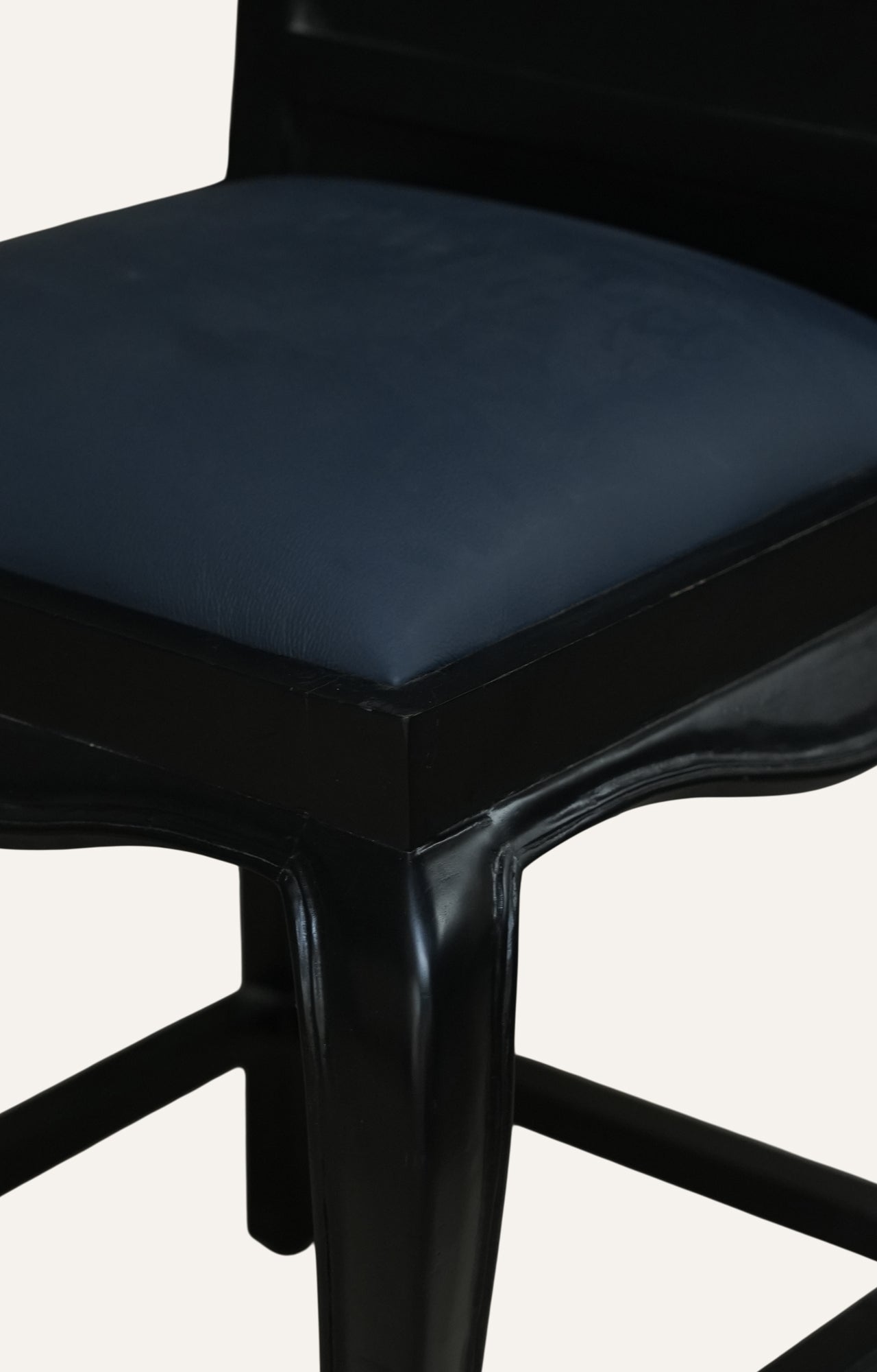 Black bar stool with a dark cushioned 