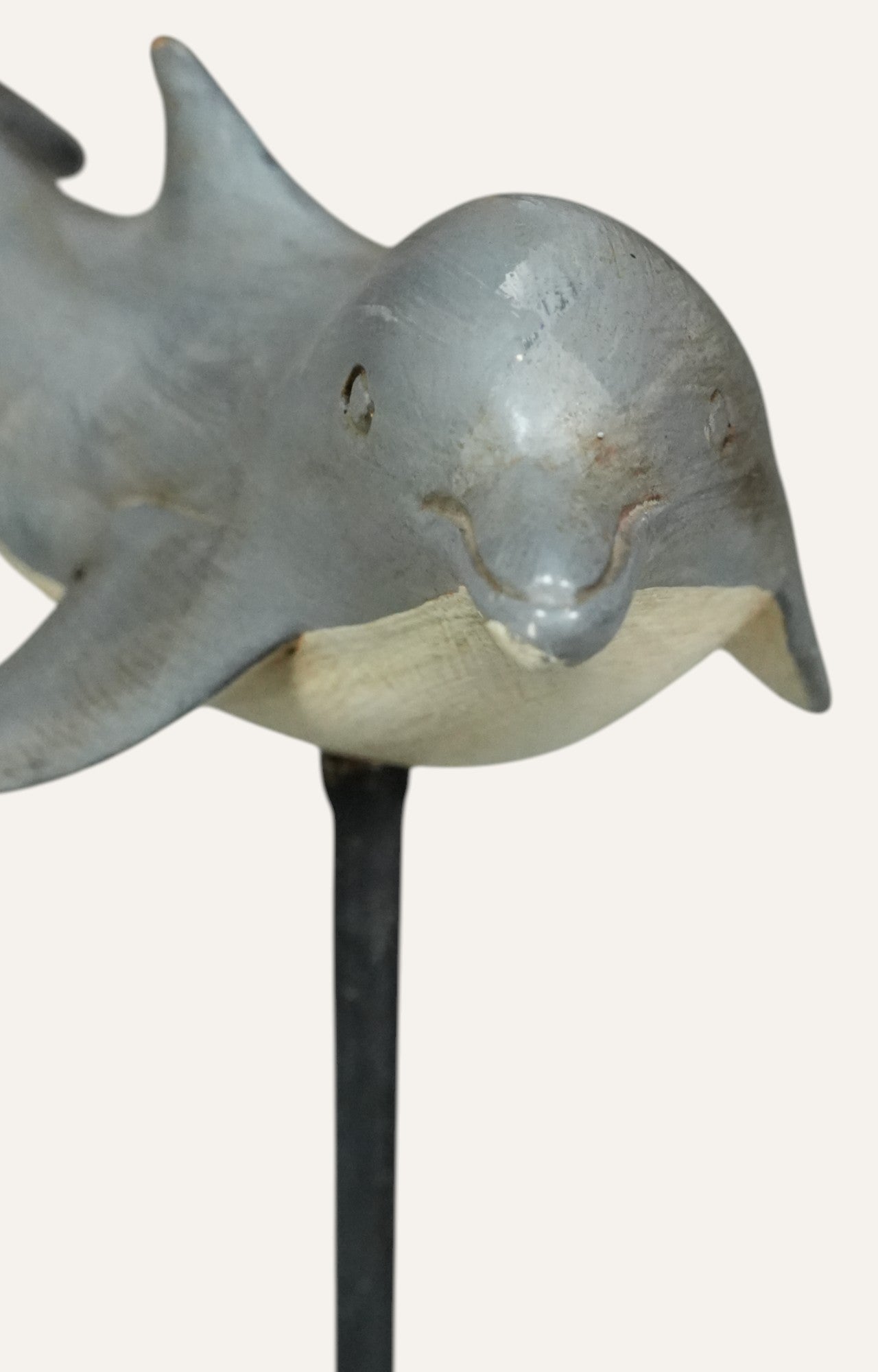 Metallic dolphin sculpture on a stand