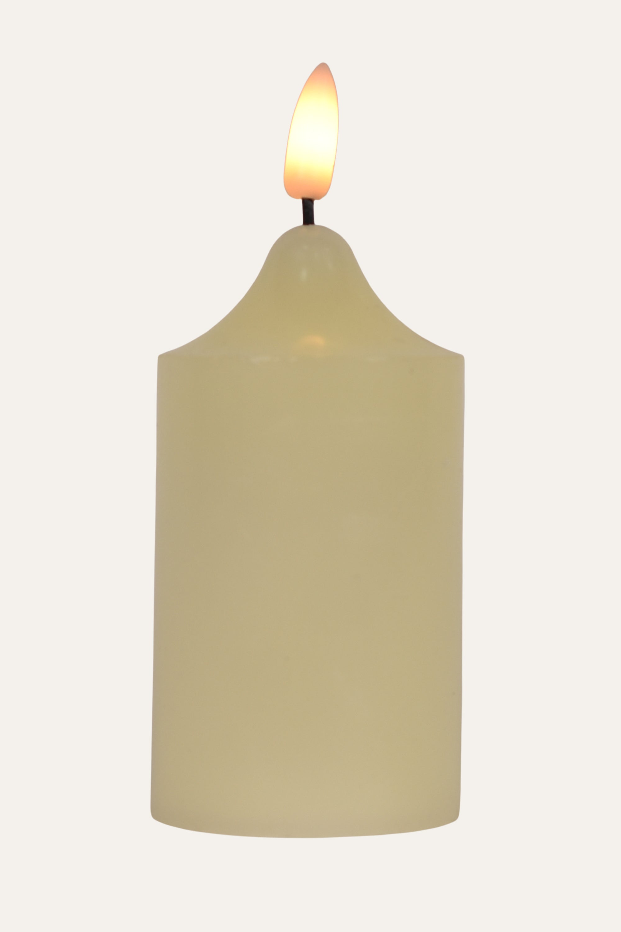 Beige candle with a lit wick