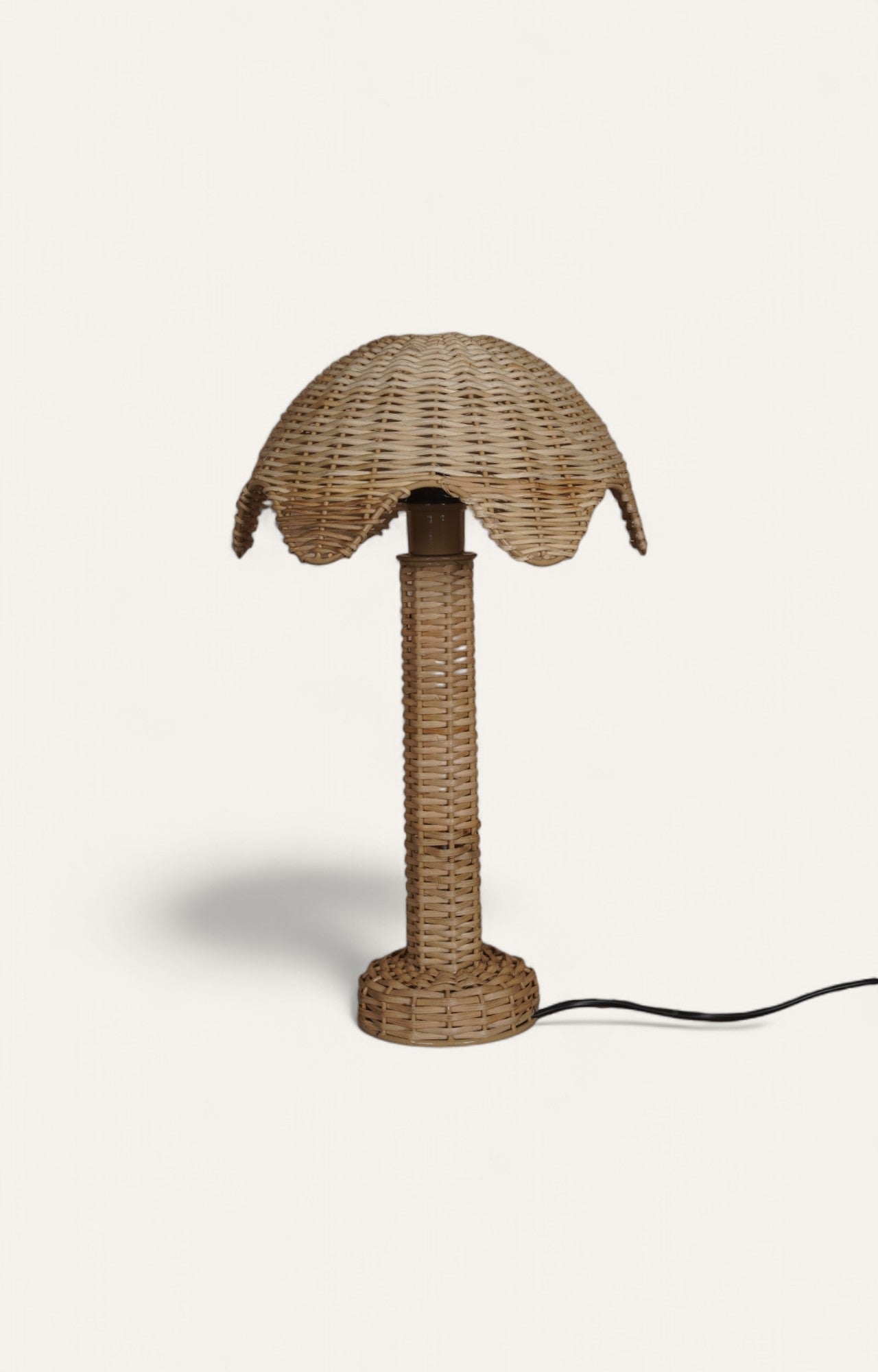 Table lamp with natural cane ropes wrapped in a scalloped pattern around a metal frame.