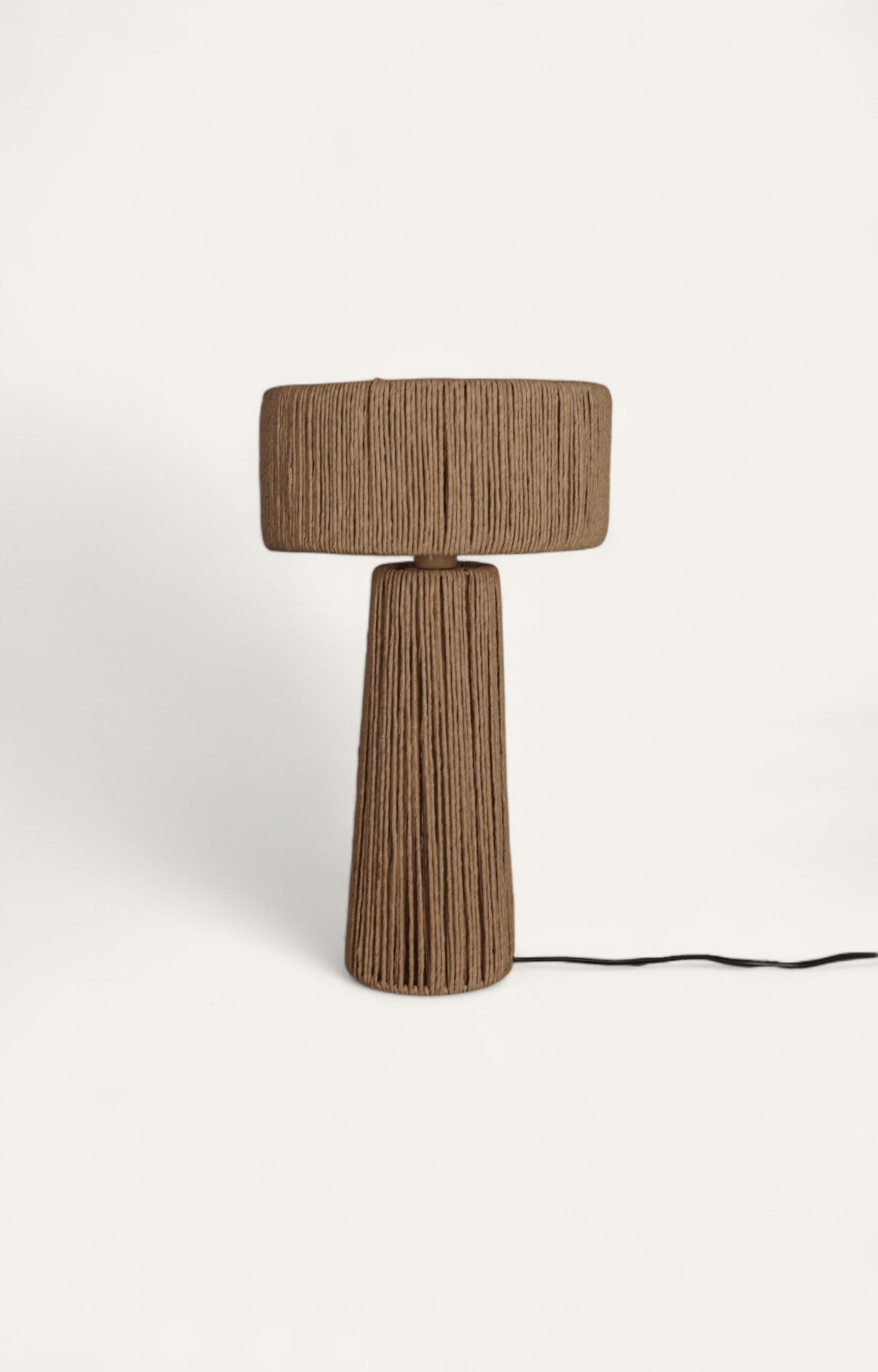 Table lamp with a cylindrical drum shade and base wrapped in brown raffia ropes.