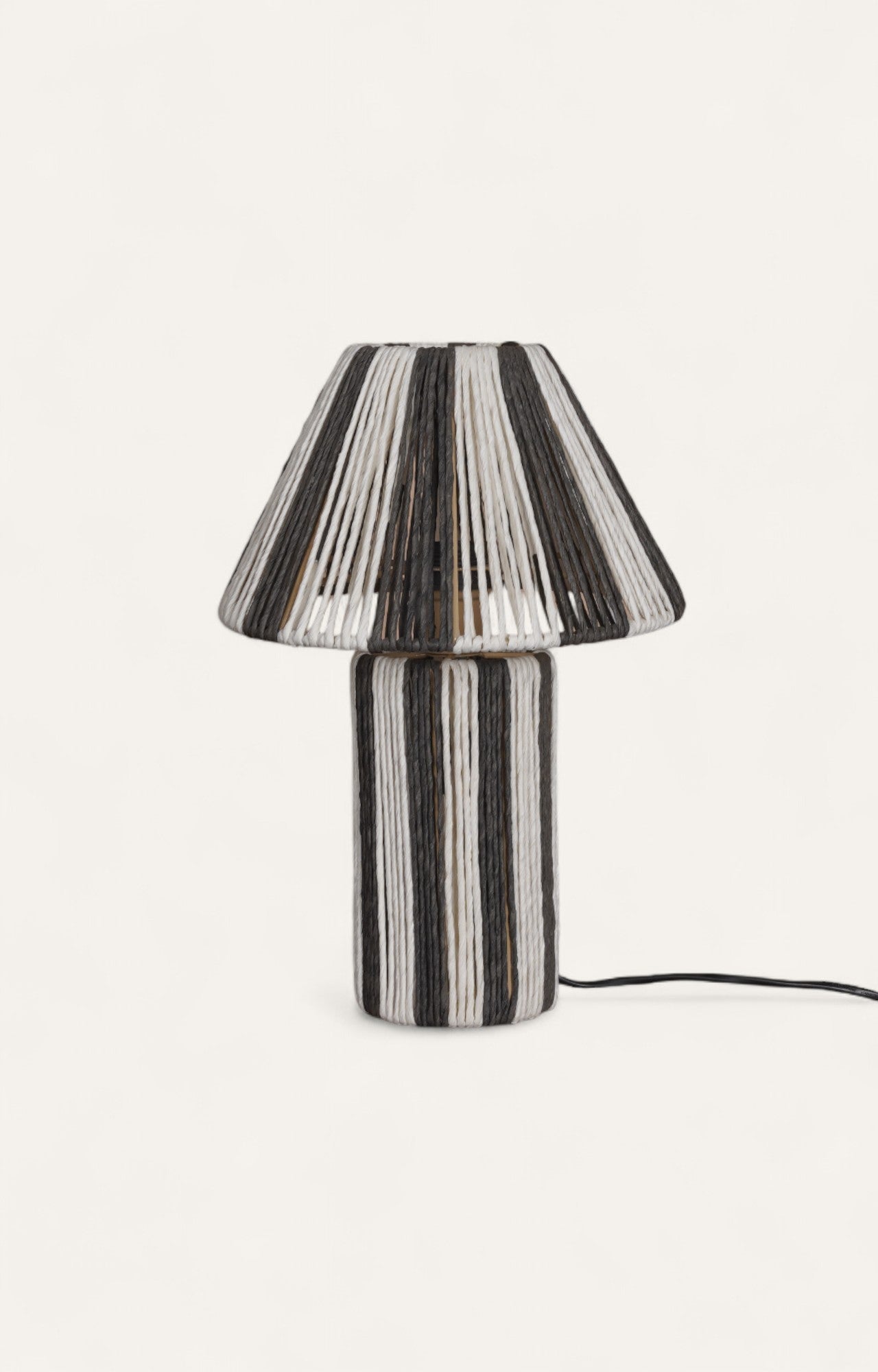 Table lamp with vertical blue and white stripes created from textured raffia ropes wrapped around a metal frame.