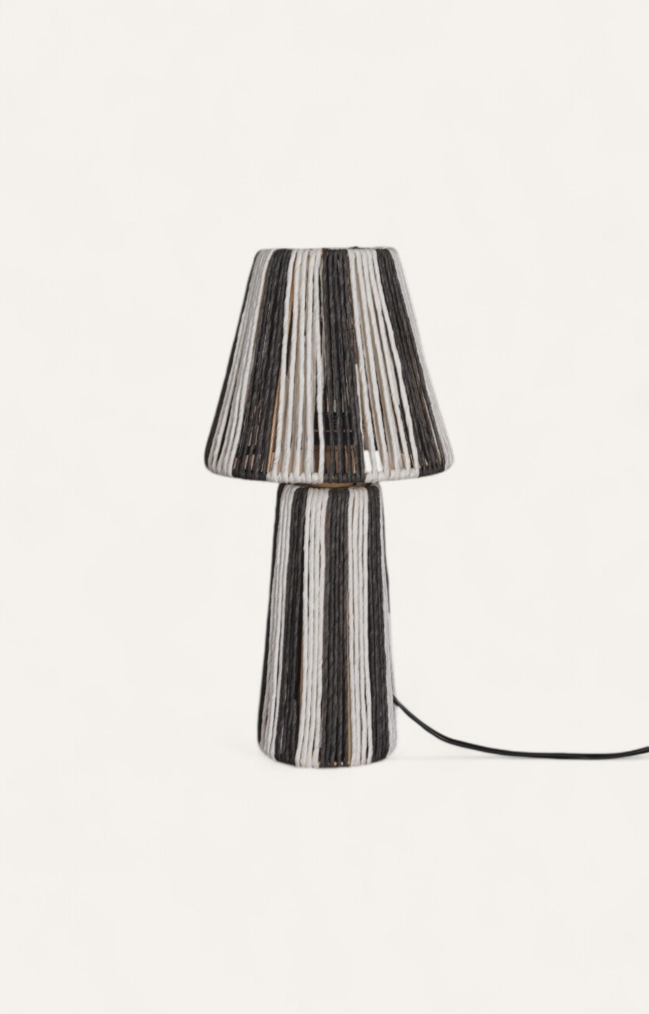 Table lamp with black and off-white raffia ropes arranged radially on the shade and vertically on the base.